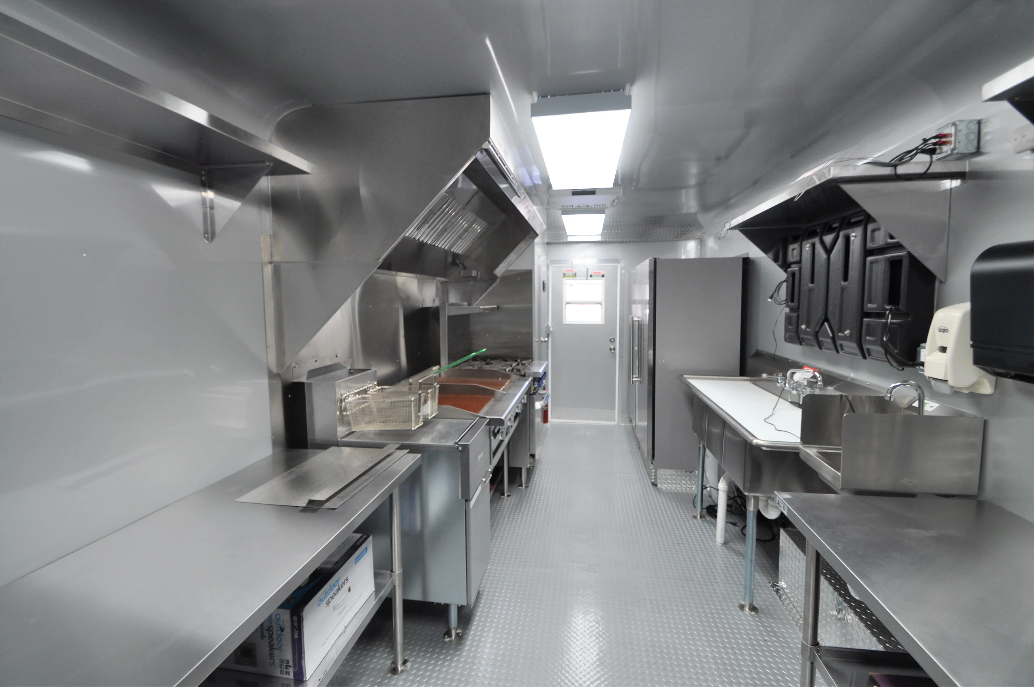 Inside an Expandable gaming trailer with vibrant lighting and multiple gaming setups. Attendees interact near high-tech gaming equipment under a bold Intel and Erazer branding backdrop.